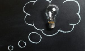 clear light bulb placed on chalkboard